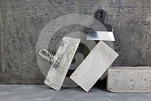 bricks, putty knife on the gray concrete background. Copy space. Top view