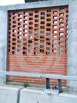 Bricks show and cement wall beside road.