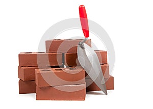Bricks and a trowel on white