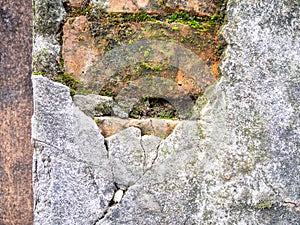 Brickwork breaks through under the cement. Background from an old wall and moss. Mold and moss on the wall. Part of an old house