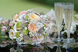 Bridal bouquet and champagne glasses on wedding car bonnet.
