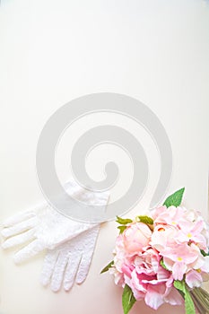Bridal bouquet and glove against white wall