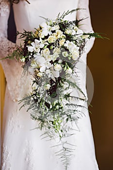 Bridal bouquet held by her with her hands at her wedding