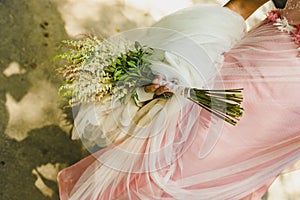 Bridal bouquet held by her with her hands at her wedding