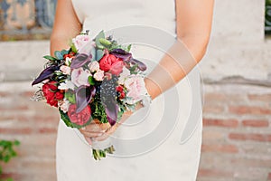 Bridal bouquet held by her with her hands at her wedding