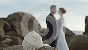 Bridal bouquet and newlyweds in love out of focus