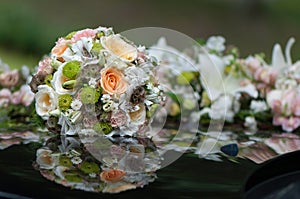 Bridal bouquet placed on wedding car bonnet.