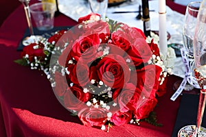 Bridal bouquet of red roses on table