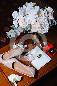 Bridal bouquet, two buttonholes, women`s shoes, wedding rings in a box, women`s bracelet, envelope with a wed