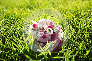 A bridal bouquet of various flowers in grass