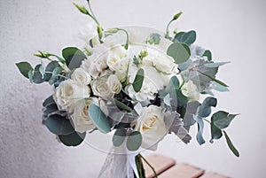 Bridal bouquet of white rose and lisianthus with eucalypt. horizontal image.