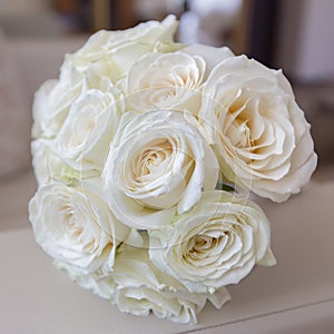 Bridal bouquet from white roses on armrest of sofa