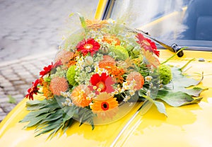 Bridal bouquet on a yellow wedding car