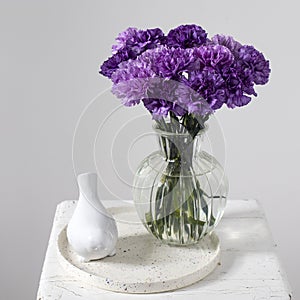 Bridal bouquets of lilac carnations in four round glass vases different sizes as table decoration
