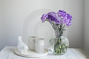 Bridal bouquets of lilac carnations in four round glass vases different sizes as table decoration