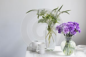 Bridal bouquets of lilac carnations in a four round glass vases different sizes as table decoration