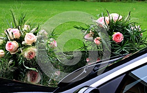 Bridal bouquets mirroring in glossy black car