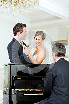 Bridal couple in front of a piano