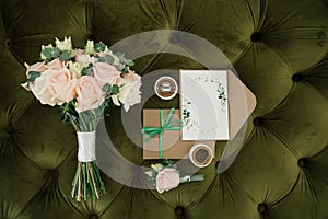 Bridal morning details composition. Top view of wedding rings, beautiful bouquet of pink flowers with ribbons. Flat lay