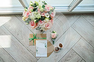 Bridal morning details composition. Top view of wedding rings, beautiful bouquet of pink flowers with ribbons. Flat lay