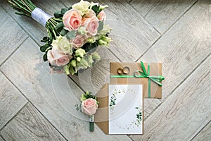 Bridal morning details composition. Top view of wedding rings, beautiful bouquet of pink flowers with ribbons. Flat lay