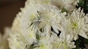 Bridal wedding bouquet and Hawaiian lei wreath made of white orchids on table in the room. No people. Camera on slider