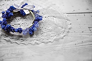 Bridal wreath lying on a lace napkin. Wedding accessories. Blue flowers.