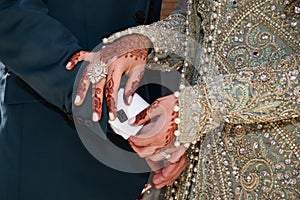 Bride adjusting cufflink on asian husband
