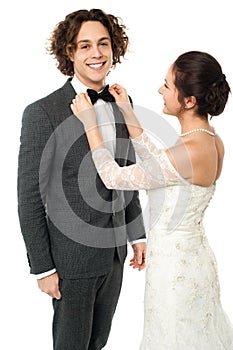 Bride adjusting her man's bow tie