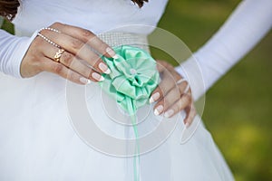 Bride adjusts flower on her dress