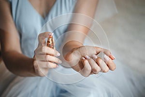 Bride applying perfume on her wrist