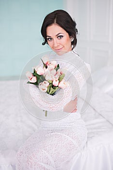A bride in a beautiful dress holding a bouquet of flowers . Wedding. Bride`s morning. Fine art
