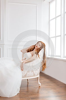 Bride in beautiful dress laying resting on sofa indoors