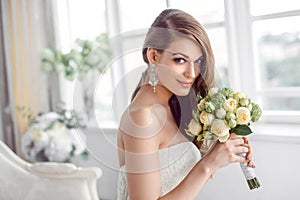 Bride in beautiful dress sitting resting on sofa indoors