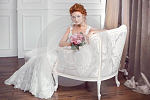 Bride in beautiful dress sitting resting on sofa indoors