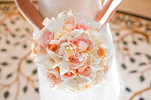 Bride with beautiful orange and pink wedding bouquet of flowers