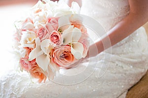 Bride with beautiful orange and pink wedding bouquet of flowers