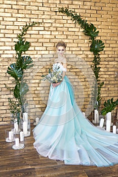 Bride in a beautiful turquoise dress in anticipation of wedding. Blonde in lace dress sea green with a bouquet . Happy bride