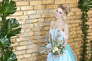 Bride in a beautiful turquoise dress in anticipation of wedding. Blonde in lace dress sea green with a bouquet . Happy bride