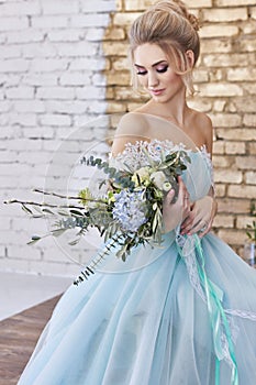 Bride in a beautiful turquoise dress in anticipation of wedding. Blonde in lace dress sea green with a bouquet . Happy bride