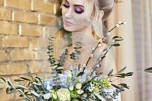 Bride in a beautiful turquoise dress in anticipation of wedding. Blonde in lace dress sea green with a bouquet . Happy bride