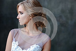 Bride blonde woman in a modern color wedding dress with elegant hair style and make up. Fashion beauty portrait