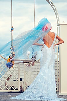 Bride with blue veil near swing