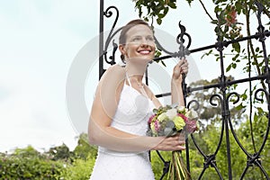 Bride With Bouquet Standing By Gate