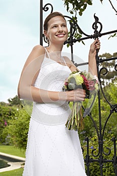Bride With Bouquet Standing By Gate