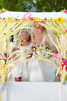 Bride And Bridesmaid Sitting Under Decorated Canopy