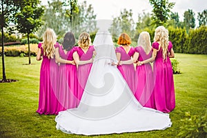 Bride with bridesmaids in a park photo