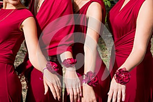 Bride and bridesmaids with red bracelets on hands. Close up hands.