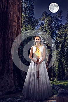 Bride with the burning torch in the night wood