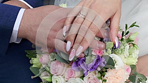 Bride caresses the groom's ring.